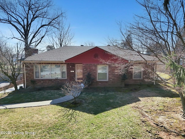 view of front of property with a front yard, brick siding, and a shingled roof