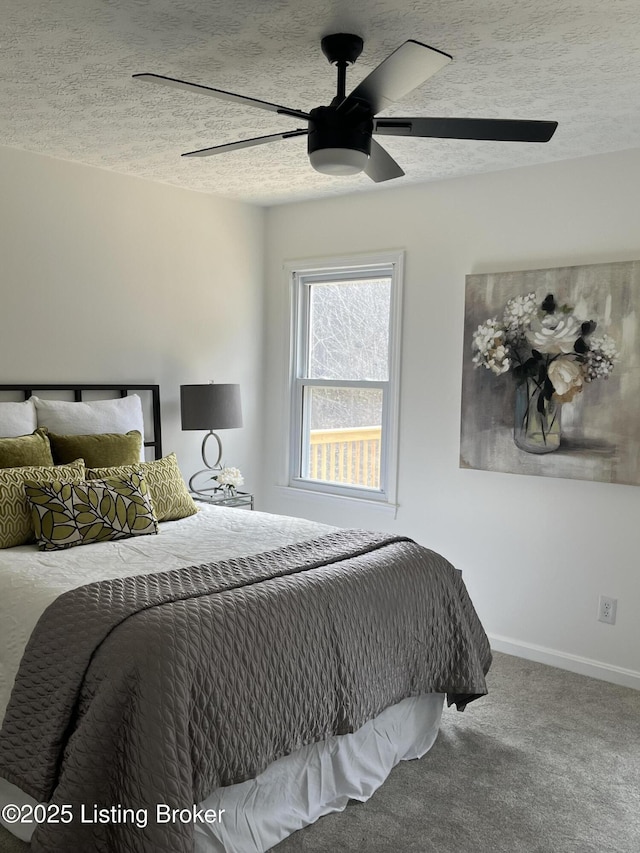 bedroom featuring baseboards, carpet flooring, a textured ceiling, and a ceiling fan