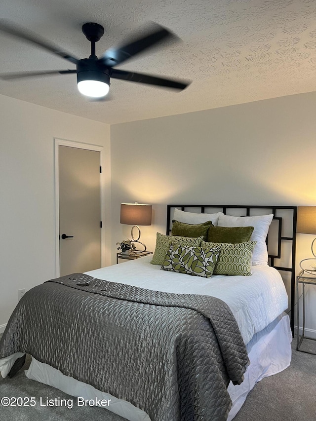 bedroom with carpet flooring, a textured ceiling, and a ceiling fan