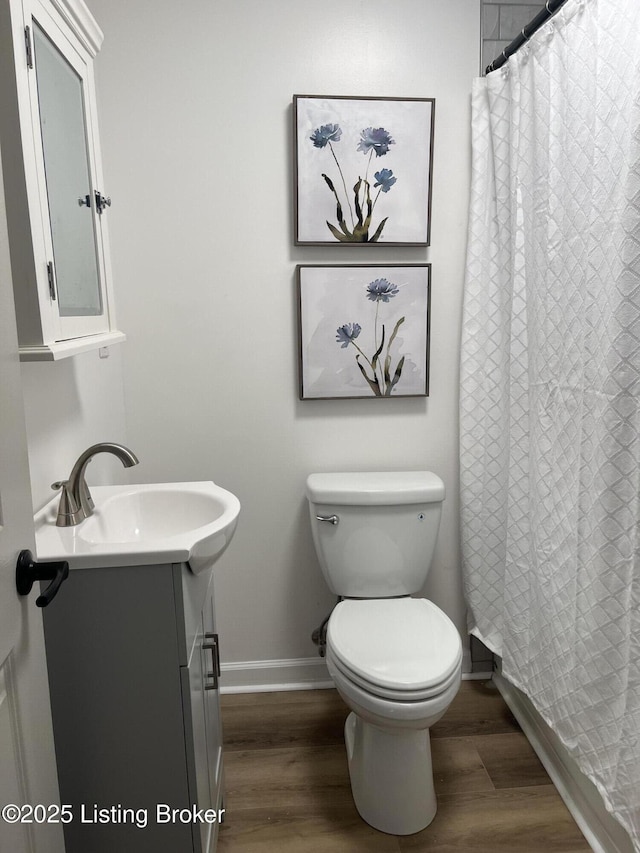 full bathroom with vanity, toilet, wood finished floors, and baseboards