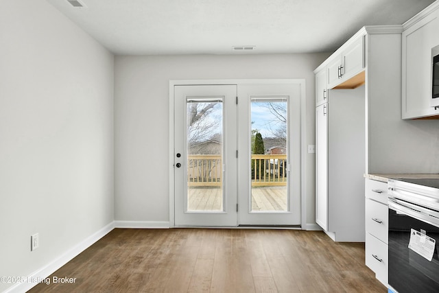 entryway featuring visible vents, baseboards, and wood finished floors