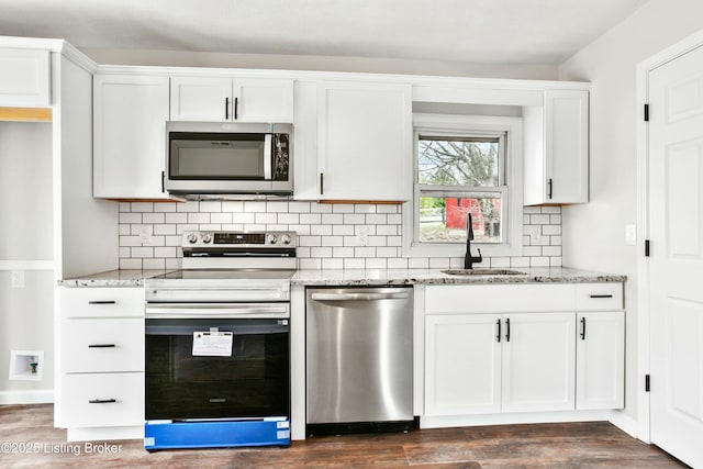 kitchen with a sink, light stone countertops, backsplash, and stainless steel appliances