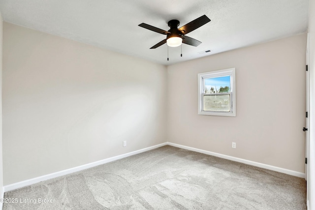 carpeted spare room with a ceiling fan, visible vents, and baseboards