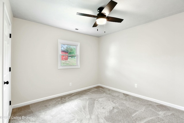 carpeted spare room with baseboards and ceiling fan