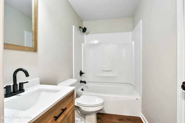 bathroom with vanity, toilet, wood finished floors, and tub / shower combination