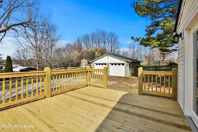 wooden terrace featuring a garage and an outbuilding