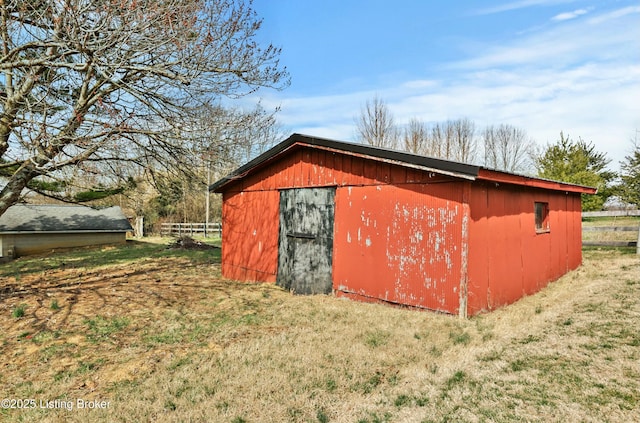 view of outbuilding featuring an outdoor structure and fence