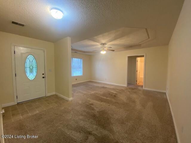 entryway with visible vents, carpet floors, a textured ceiling, and baseboards