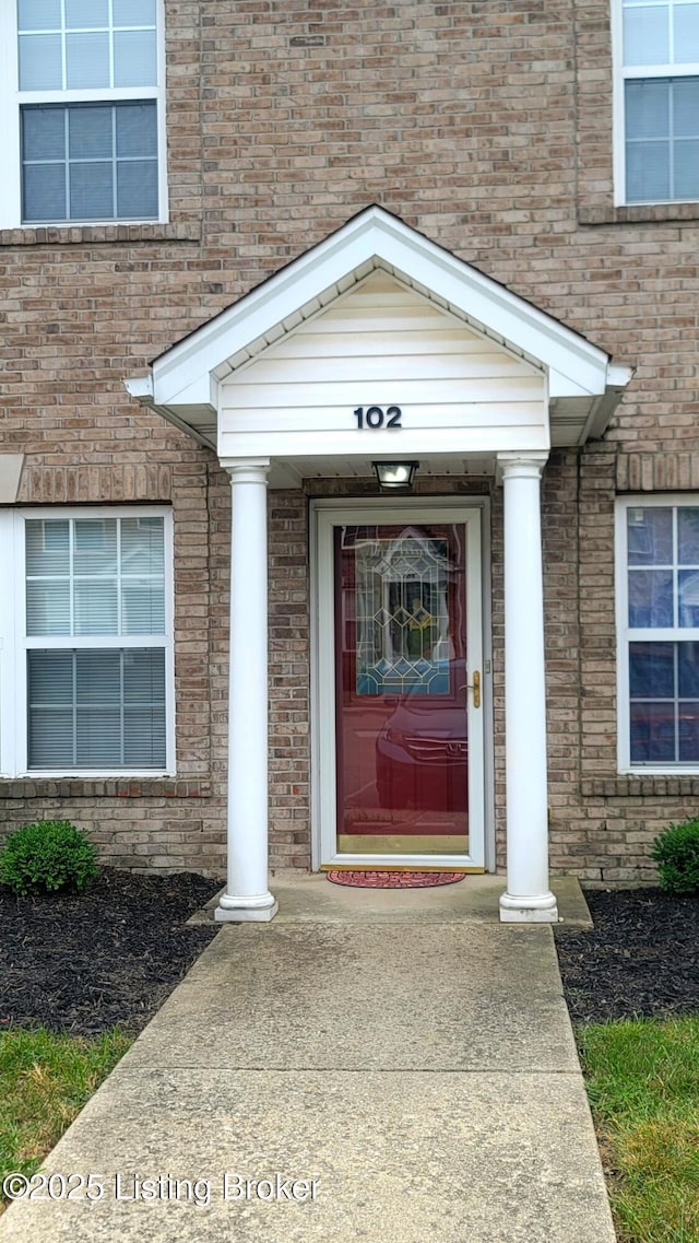 doorway to property with brick siding