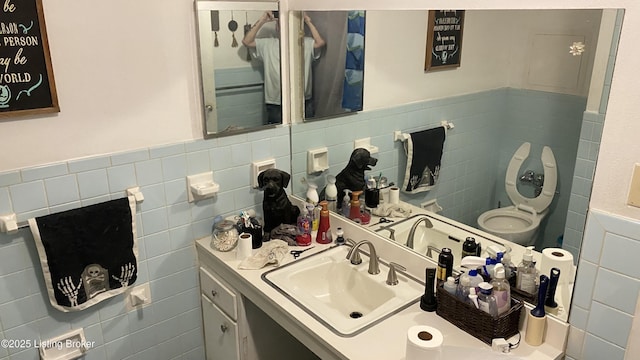 bathroom featuring a wainscoted wall, tile walls, and vanity