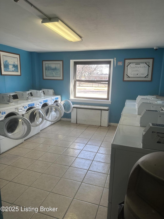 common laundry area with light tile patterned floors, independent washer and dryer, and baseboards