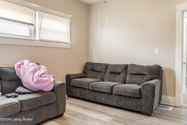 living room featuring visible vents, baseboards, and light wood-style flooring