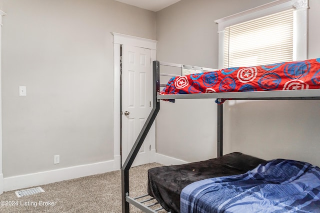 carpeted bedroom featuring baseboards and visible vents