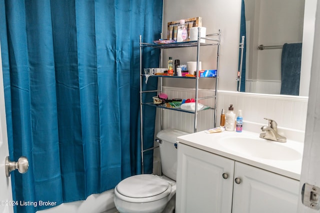 full bathroom featuring wainscoting, toilet, vanity, and shower / bathtub combination with curtain