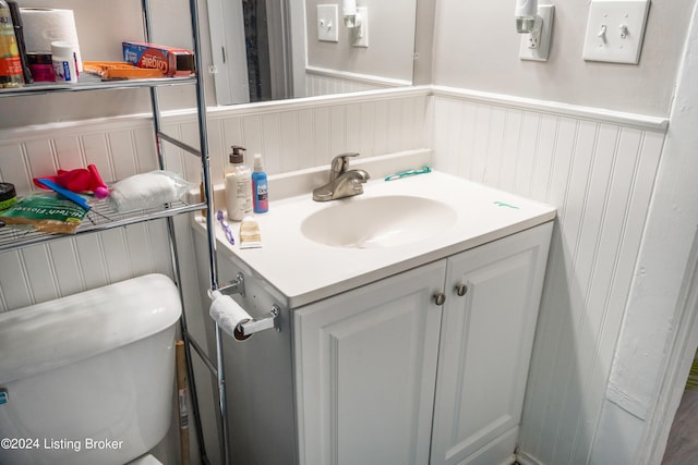 half bathroom with a wainscoted wall and vanity