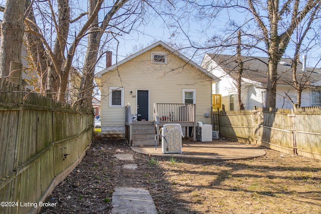 rear view of house with a chimney, cooling unit, a wooden deck, and fence