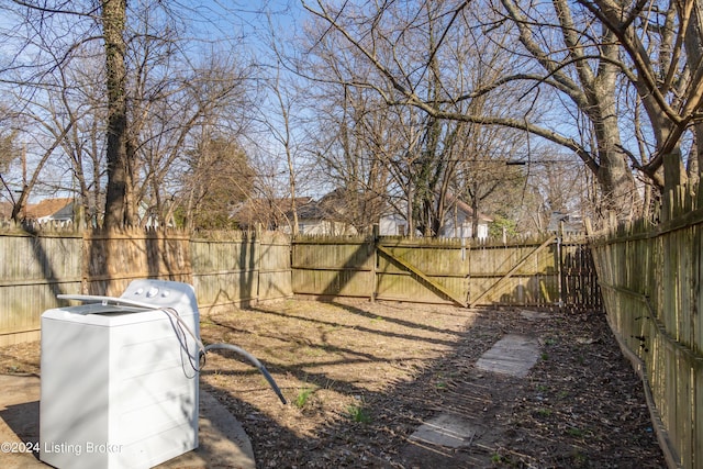 view of yard featuring washer / clothes dryer and a fenced backyard