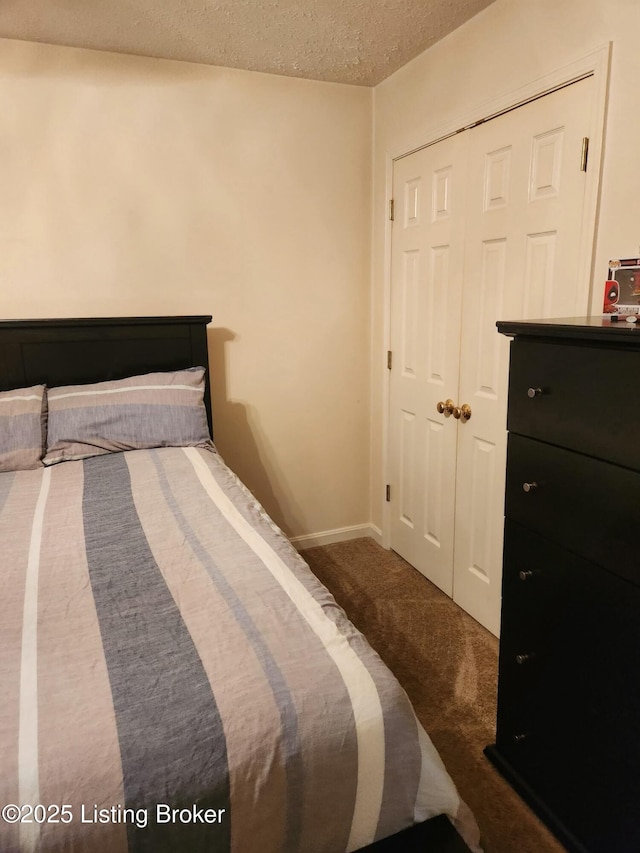 bedroom featuring a closet, carpet floors, a textured ceiling, and baseboards