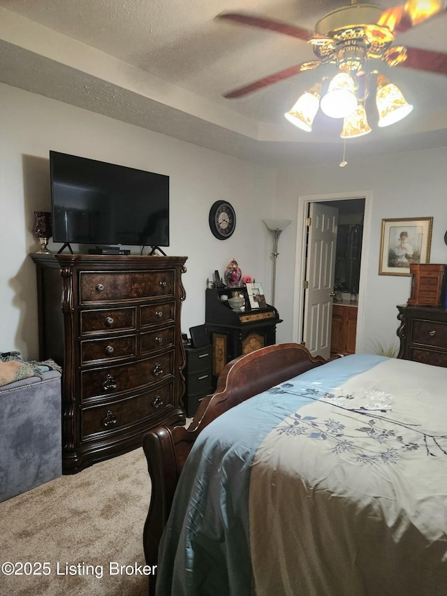 carpeted bedroom featuring a textured ceiling and a ceiling fan