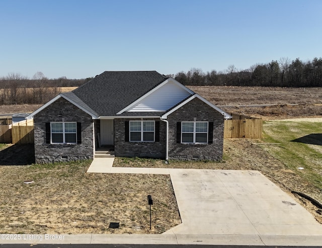 view of front of house featuring crawl space, brick siding, roof with shingles, and fence