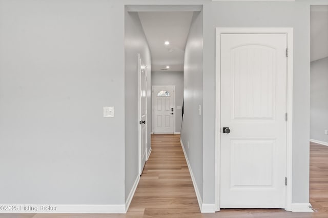 hall featuring baseboards and light wood-style floors