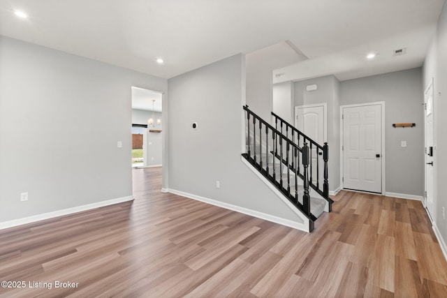 entryway with stairs, visible vents, baseboards, and light wood finished floors