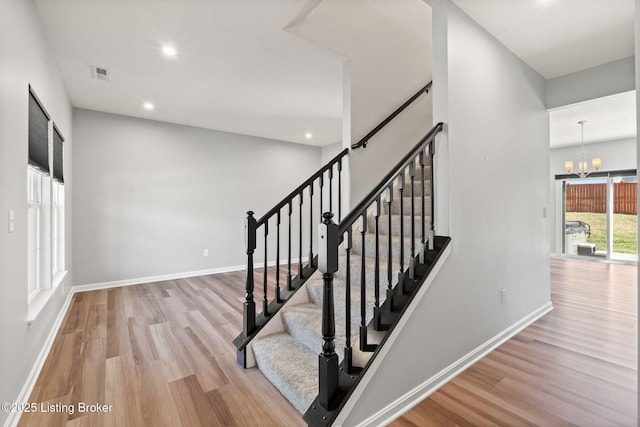 stairs featuring recessed lighting, baseboards, wood finished floors, and a chandelier