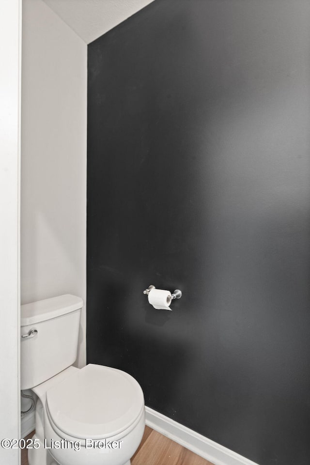 bathroom featuring toilet, wood finished floors, and baseboards