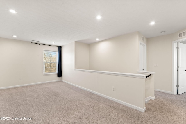 unfurnished room with recessed lighting, baseboards, light carpet, and visible vents