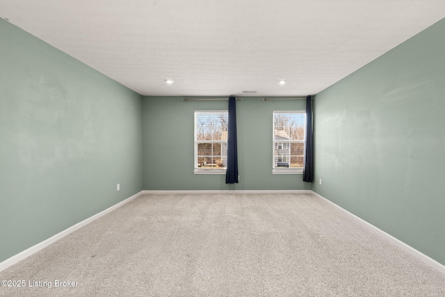 spare room featuring recessed lighting, baseboards, and carpet floors