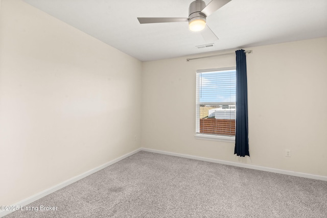 spare room with a ceiling fan, carpet, and baseboards