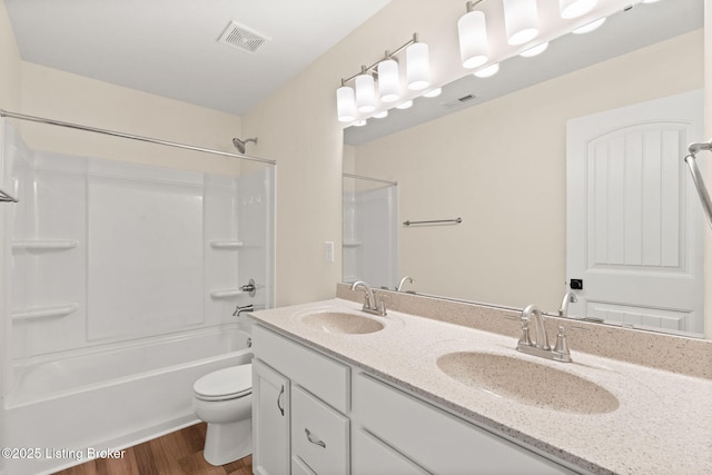 full bath with wood finished floors, toilet, visible vents, and a sink