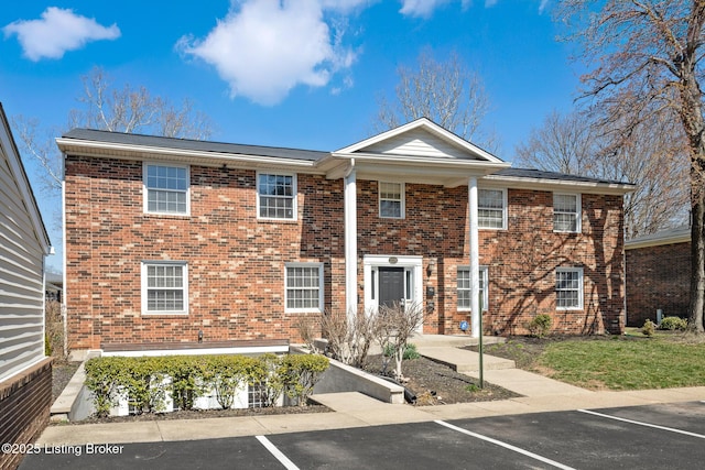 view of front of house featuring brick siding and uncovered parking