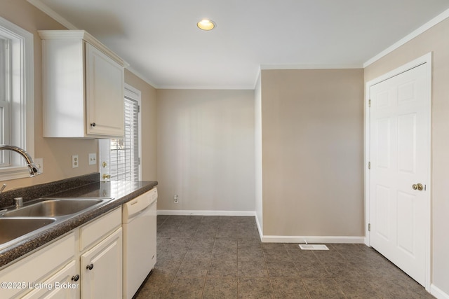 kitchen featuring dark countertops, baseboards, ornamental molding, white dishwasher, and a sink