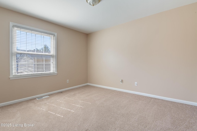 carpeted spare room featuring visible vents and baseboards