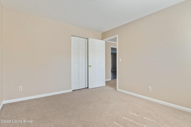 unfurnished bedroom with baseboards, a closet, and light carpet