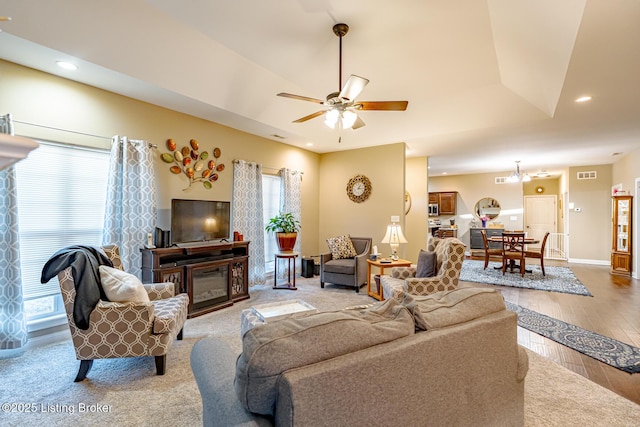 living room with plenty of natural light, recessed lighting, and a glass covered fireplace