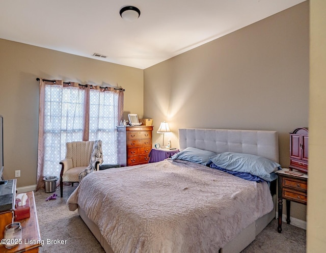 carpeted bedroom featuring visible vents and baseboards