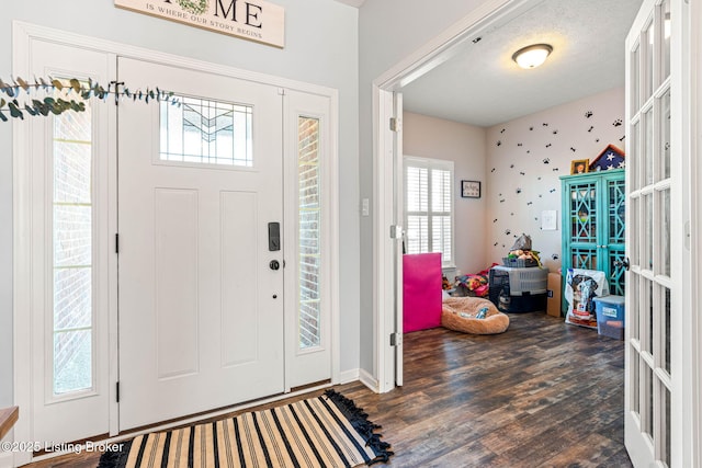 entryway with wood finished floors, french doors, and a textured ceiling