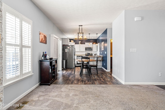 dining space featuring baseboards and dark carpet