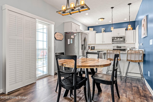 dining area featuring visible vents, a textured ceiling, dark wood finished floors, recessed lighting, and baseboards