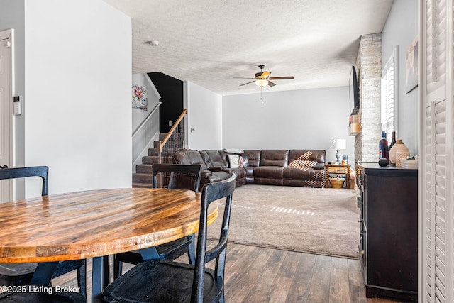 dining space with stairs, a ceiling fan, wood-type flooring, and a textured ceiling