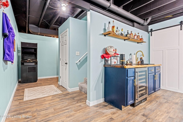 bar with beverage cooler, stairs, indoor wet bar, light wood-style floors, and a sink