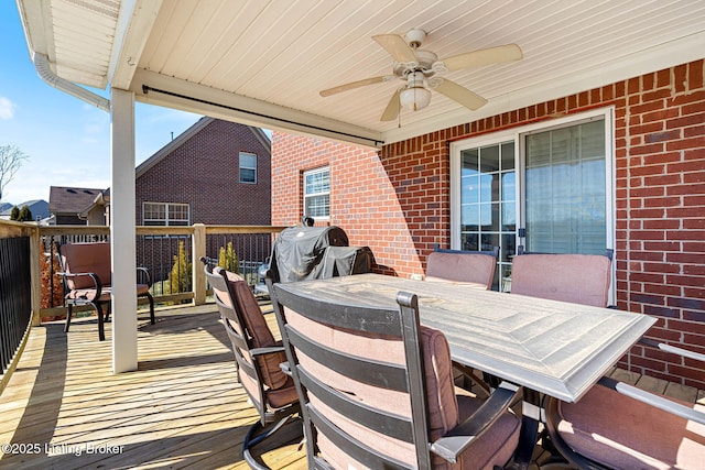 wooden deck with area for grilling, outdoor dining area, and ceiling fan