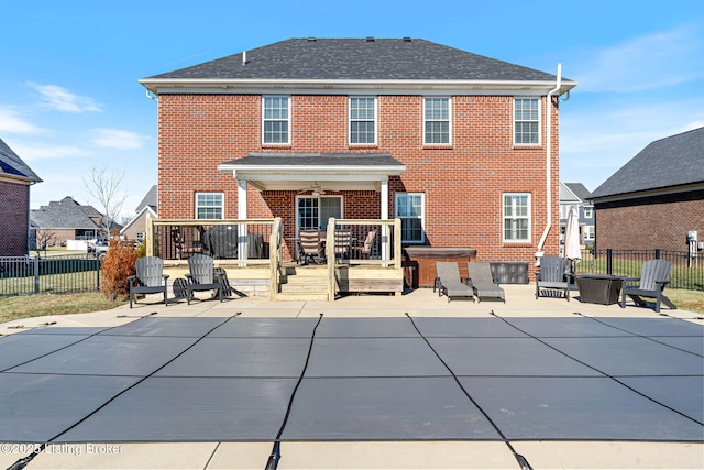 back of house with a wooden deck, a patio, brick siding, and fence