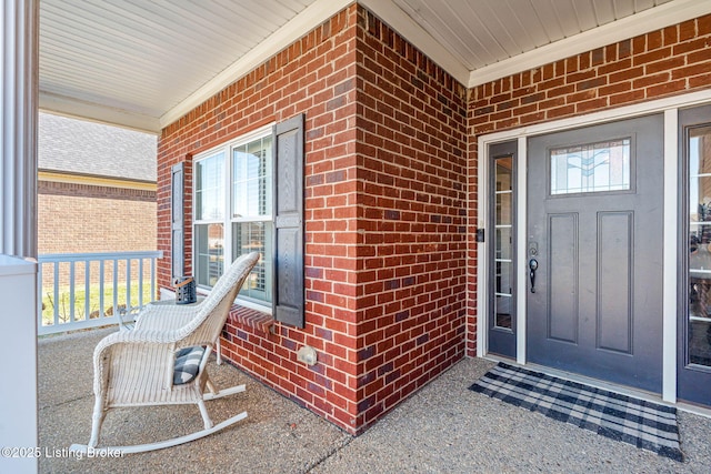 entrance to property with brick siding and covered porch