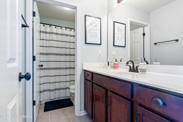 full bathroom featuring tile patterned floors, toilet, curtained shower, a textured ceiling, and vanity