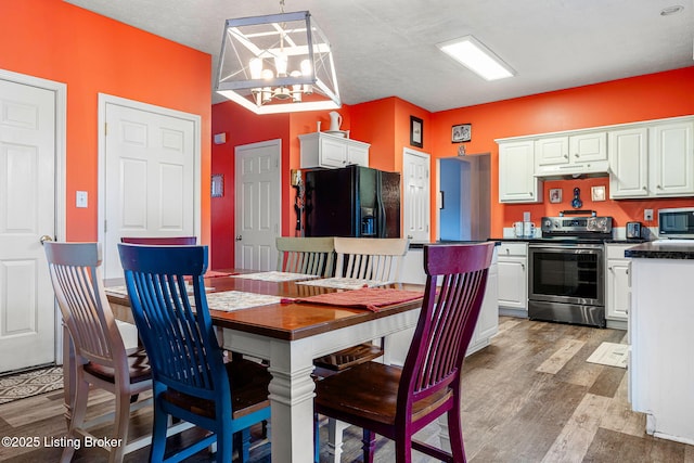 dining area featuring an inviting chandelier and wood finished floors