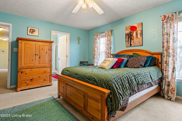 bedroom featuring light carpet, a textured ceiling, and ceiling fan