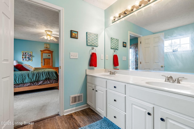 bathroom featuring visible vents, a textured ceiling, a ceiling fan, and a sink